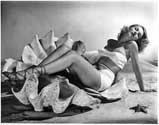 Anita Colby poses seductively for her role in "Cover Girl", 1944. Playing herself in the film, she is joined by many other actresses fulfilling magazine cover-girl roles from the more popular mags of the day. Anita Colby is the only authentic cover girl on the set, having already created a name for herself as a top tier fashion model of the day. Ned Scott often used the motif of the giant clam shell (a real artifact from the set crew) to emphasize his subjects' available feminity. Charles Vidor's musical comedy, "Cover Girl", 1944. 