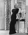 Photographed at her home in Beverly Hills, Anita Louise poses in a fashionable dinner dress ensemble of black crepe by designer Traina-Norrell. Her antique necklace and bracelet are of gold mesh studded with diamonds. Ned Scott captured the essence of the Hollywood’s Golden Age in this glamour pose of understated elegance. Anita Louise had just begun filming in director Henry Levin’s period-piece action adventure, "The Fighting Guardsman", 1946.