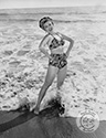 Fun loving dancer Ann Miller, here captured while cavorting in the Malibu surf by Ned Scott, goes the extra mile to support her role for the Columbia Studios film, "Eadie Was A Lady", 1945, directed by Arthur Dreifuss. Ann plays the role of Edi Alden, a nightclub dancer who is supporting herself while attending college courses. This scene is the beach below the cliffside residence of sculptress Cornelia Runyon.
