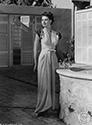 Ned Scott chose this setting for a full body portrait of Dusty Anderson in the film "One Way To Love". Dusty had appeared before Ned Scott's camera in several prior films, and he knew her well. Perhaps it was this familiarity which stimulated him to create a Grecian feel to highlight her statuesque beauty. Dusty's character in this film is a WAC officer, Capt. Henderson, who finds herself on a train bound for California. Her fellow passengers include a group of radio writers with devious objectives. Things heat up when she becomes involved in their wacky plots. Director Ray Enright's media comedy, "One Way To Love", 1946.