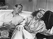 Irene Dunn and Douglas Fairblanks, Jr. share a jocular moment during the filming of Director Tay Garnett's romantic musical comedy, "Joy of Living", 1938.
