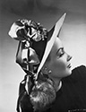 This intriguing fashion portrait of Janet Blair highlights facial profile offset by a highly decorative hat which dominates the image. This portrait was created at the same time Janet Blair was filming Director Alfred E. Green’s "Tars and Spars", 1946, at Columbia Studios. Hats were chic and popular in the day. For a different film a year later, Columbia Studios’ costume designer Jean Louis Berthault presented Rita Hayworth with a hat he had brought all the way from Paris for her costume. 