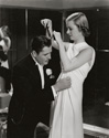 Joan Bennett and Warner Baxter, photographed here off-stage, prepare each other with last minute adjustments to attire before a big shindig. Joan plays Wendy Van Klettering who is bored with her priveleged life and seeks some adventure at the stern disapproval pf her parents. Wraner Baxter plays high fashion clothing designer George Curson who enables and encourages Wendy's modeling career. Irving Cummings romantic comedy 'Vogues of 1938", 1937. 