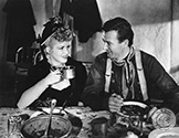 John Wayne and Claire Trevor share a light moment on set as the Ringo Kid and the Outcast Girl in Director John Ford's epic Western saga, "Stagecoach", 1939.