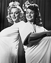 Rita Hayworth and Leslie Brooks take five during shooting of the chorus line sequence in Director Charles Vidor’s musical comedy, "Cover Girl", 1944. This is an adorable off-set portrait of these two high energy stars from Columbia Studios. Leslie and Rita, a dancing duo, collaborated in several films from Columbia in the mid-’40’s. Photographs such as these were destined for newspaper publication where they stimulated public interest and improved ticket sales.