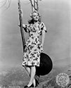 Leslie Brooks poses outdoors on a Spring morning with appropriate pointed flower motif in the foothills surrounding Los Angeles. Ned Scott created this image to support her role as Angela in Director Victor Saville’s musical biopic of a WWII London playhouse, "Tonight and Every Night", 1945. During the London Blitz, this playhouse never went dark and held performances despite the nightly bombings of the city.
