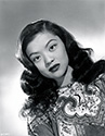 In full costume regalia, Maylia poses for a portrait to support her role as Shu Pan Wu, Chinese drug villain in Columbia Pictures' To The Ends of the Earth, 1948. Only 20 years old when sitting for this portrait in her debut film, Maylia was billed by Columbia as the next Anna Mae Wong. Columbia had big plans for her, but this was not to be. She met and married actor Benson Fong only a few weeks into filming, and quickly became pregnant with her first child. Sadly, her stunted career produced only a few films and images such as this one. She remained married to Fong until his death in 1985. Maylia means 'beautiful' in Cantonese.