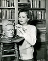 Dutch born Columbia Pictures star Nina Foch applies the finishing touches to a bust of actor Dick Dickerson in her library. Besides starring in Columbia's film noir, My Name Is Julia Ross, Nina Foch spends her spare time creatively in this 1945 gag shot by Ned Scott.