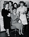 Rosalind Russell signs autographs for a group of hair stylists at Columba Studios in 1943 while she was starring in 'What a Woman'. From left to right, flanking Rosalind Russell who is seated, are Rhoda Donaldson, Hazel Keats, Flore' and Helen Hunt, chief hair stylist for Columbia Pictures.