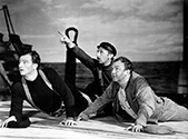 The Long Voyage Home photos: Three of the SS Glencairn’s crew react to the attack by a German warplane on their vessel. Ole, played by John Wayne, Axel played by John Qualen, and Driscoll the Bosun, played by Thomas Mitchell all cower in fear and dread as the warplane cricles their vessel in John Ford’s epic tale of the sea, The Long Voyage Home, 1940