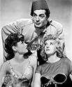Gene Tireney, seen here in her role as "Poppy" and her playful friend, Dixie, played by Phyllis Brooks are both gloated over by the supreme low-life Dr. Omar, played by Voctor Mature. Omar has purposely currupted these two in a ploy to obstruct the plans of a wealthy Shanghai entrepreneur whose dayghter happens to be none other than the fun-loving "Poppy". Director Josef von Sternberg's film noir crime drama, "The Shanhai Gesture", 1941.