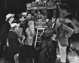 The entire cast join Director John Ford for a formal presentation of a bronze statuette to memorialize the Ford's epic western drama, "Stagecoach" 1939. Studio caption on the verso reads: Hollywood's memorial to Will Rogers--A 16 foot bronze fire of the late humorist Will Rogers riding on a cow pony and bearing the inscription 'I never met a man I didn't like' is soon to be erected on the prominent corner of Hollywood Blvd. in the Film Capital. Sculptress Jean Wildenrath gave the cast of Walter Wanger's "Stagecoach" a preview of the statue because director John Ford directed Rogers in a number of pictures and Andy Devine was one of the late star's closest friends. Left ro right, Donald Meek, Minta Dufree, Chairman of the Rogers Memorial Statue Committee, John Carradine, Andy Devine, John Wayne, sculptress Wildenrath, George Bancroft, Louise Platt, Thomas Mitchell, Director Ford and Berton Churchill."