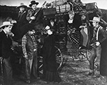 After the second leg of their journey to Lordsburg, the passengers dismount from the stage in the courtyard of the Apache Wells relay station. All hands are present to witness the exchange between the station proprietor Chris (Chris-Pin Martin) and Lucy Mallory (Louise Platt), the pregnant wife of Lt. Blanchard (Tim Holt), the U.S. Cavalry officer stationed in the area. Chris breaks the bad news to Mrs. mallory that her husband was just injured in a skirmish with Apache warriors. Chris also says that going on to Lordsburg is risky and perilous because Apaches have just attacked in several places along the route. Director John Ford’s epic frontier drama, "Stagecoach", 1939. 