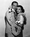 Trade Winds photos: Studio caption for this photograph reads: Fredric March and Joan Bennett, a new screen team, are a delightful pair of lovers in "Trade Winds", Walter Wanger's adventure romance which takes them half way around the world during the course of the story. The picture presents a new and very brunette Joan Bennett, since she is seen with dark brown hair except in the opening sequences." An off-set photograph supporting Director Tay Garnett's lighthearted murder mystery, "Trade Winds", 1938. 