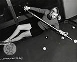 Evelyn Keyes lines up a challenging shot on the pool table at her home. This image was used to support her role in Johnny O'Clock, 1948