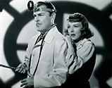 Brain Donlevy as Dr. Svoboda and Anna Lee as Masha Novotny sequester themselves against the threat of searching Nazi agents in Hangmen Also Die, 1943.