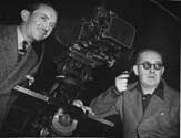 Director John Ford and cinematographer Bert Glennon pose for a working shot during filming of the classic Western drama, Stagecoach, 1939. 