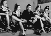 Photos of Jimmy Stewart: Jimmy Stewart shares a light moment in an off-set gag shot with chorus girls who are taking a break from their dance moves in Director George Marshall's romantic comedy 'Pot O' Gold', 1941