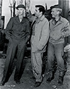 One of Ernie's fellow War Correspondents assigned to the film production of The Story of G. I. Joe teases Ernie about his regulation haircut and knit hat which Ernie always wore at the front. Burgess Meredith who played the role of Ernie in the film, looks on with approval. On the set during filming, Meredith wore this hat or one identical to it for authenticity. 