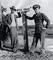 Ernie Pyle poses with Corporal James Slayton, one of the most decorated G.I.'s of World War II. At Camp Baldwin, the headquarters for the infantry company which appeared in The Story of G.I. Joe, the track which circumnavigated the camp was renamed Pyle Road in Ernie's honor. 