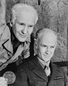 Ernie Pyle and Burgess Meredith share an amiable moment off set for photographer Ned Scott during filming of director William Wellman’s epic wartime drama, “The Story of G.I. Joe”, 1945.