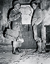 Exhaustion dogged the soldiers on front line campaigns. Supplies like food and fresh water were scarce at times, and on occasion, marching went on for days with heavy loads. Here Burgess Meredith as Ernie Pyle confers with a combat sergeant in front of a map of the Kasserine Pass, Tunisia. Scene from The Story of G.I. Joe.
