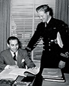 Lester Cowan reviews the script for The Story of G.I. Joe while Lt. Peter Dietrichson of the Norwegian Merchant Marine Service looks on. Lt. Dietrichson was recently signed to appear in a new film starring Greta Garbo.