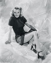 She curls up in a leggy pose to support the film 'Cover Girl', 1944.