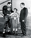 Ted Donaldson, star of Columbia's 'The Rusty' films of the mid-'40's, gets teased by Joe Dixon, center for the Los Angeles Mustangs, as 'Big Bill' Freelove, owner of the team looks on. The occasion is a gift of funds to support the Hollywood Boy's Club in its effort to outfit its baseball and football teams. Ted Donaldson was a member of the club at the time.