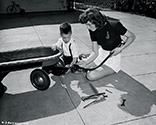 Michael Phineas gives his mother, Jeff Donnell, tips on how to repair his wagon. This photograph supported the Columbia star in her role as Anne Parks Duncan in the Boston Blackie film 'The Phantom Thief', 1946.